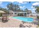 Enjoy the refreshing in-ground pool and patio area with solar panels in the background at 5761 Colonial Dr, New Port Richey, FL 34653