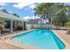 A refreshing in-ground pool is surrounded by lush landscaping, creating a private outdoor oasis at 5761 Colonial Dr, New Port Richey, FL 34653