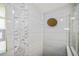 Close-up of a shower featuring a shower head with decorative tiles and glass enclosure at 5761 Colonial Dr, New Port Richey, FL 34653