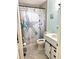 Well-lit bathroom featuring a shower with beach-themed curtain and updated vanity with a white countertop at 6880 Versailles N, Pinellas Park, FL 33781