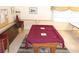 Billiards room featuring pool table covered in burgundy and stack of chairs at 6880 Versailles N, Pinellas Park, FL 33781