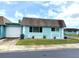Charming single-story home features a light blue exterior, well-maintained landscaping, and an attached garage at 6880 Versailles N, Pinellas Park, FL 33781