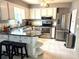Modern kitchen featuring stainless steel appliances, granite countertops, an island, and white cabinets at 6880 Versailles N, Pinellas Park, FL 33781