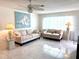 Bright living room with tile floors, neutral-toned sofas, coastal decor, and lots of natural light at 6880 Versailles N, Pinellas Park, FL 33781