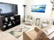 Inviting living room featuring comfortable seating, a flat-screen television, and a stylish area rug at 6880 Versailles N, Pinellas Park, FL 33781