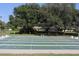 Outdoor shuffleboard courts with green surface and mature trees nearby at 6880 Versailles N, Pinellas Park, FL 33781