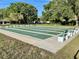 Well-maintained shuffleboard courts with benches, set in a green space and surrounded by mature trees at 6880 Versailles N, Pinellas Park, FL 33781