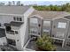 Aerial view of a condominium building with gray walls, a gray roof, and outdoor patio seating at 800 S Dakota Ave # 241, Tampa, FL 33606