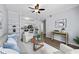 Open living room with hardwood floors, white furniture, ceiling fan, and view into the kitchen with barstool seating at 800 S Dakota Ave # 241, Tampa, FL 33606