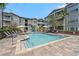 Community pool area featuring many lounge chairs, trees, and well-maintained landscaping at 800 S Dakota Ave # 241, Tampa, FL 33606