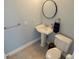 Bathroom featuring a pedestal sink, toilet, and stylish light fixtures, with modern neutral walls at 8025 Island Dr, Port Richey, FL 34668