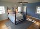 Bright bedroom with white shiplap walls, hardwood floors, and a large bed with blue accents at 8025 Island Dr, Port Richey, FL 34668