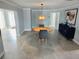Bright dining room boasts a unique light fixture and grey tile flooring, adding a modern touch at 8025 Island Dr, Port Richey, FL 34668