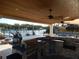 Spacious outdoor kitchen with built-in grill, bar area, and beautiful waterfront view with a pool at 8025 Island Dr, Port Richey, FL 34668