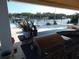 An outdoor kitchen features a built in grill, stone accents, a white fence and a view of the water at 8025 Island Dr, Port Richey, FL 34668