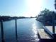 Scenic waterfront view with dock, sparkling water, and lush greenery under a clear blue sky at 8025 Island Dr, Port Richey, FL 34668