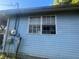 The exterior of a light blue house, showing a window with an air conditioner at 8203 N Semmes St, Tampa, FL 33604