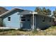 A single-story home with a blue exterior, featuring a covered front porch and a well-maintained yard at 844 Bruce Ave, Clearwater Beach, FL 33767