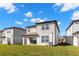 View of the rear of the property showing a large green lawn at 9066 Rally Spring Loop, Wesley Chapel, FL 33545