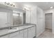 Bathroom featuring a dual sink vanity with granite countertop and tiled shower at 9066 Rally Spring Loop, Wesley Chapel, FL 33545