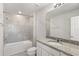 Bright bathroom features a granite-topped vanity, a bathtub with tile surround, and neutral decor at 9066 Rally Spring Loop, Wesley Chapel, FL 33545