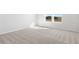 Sun-filled bedroom features neutral carpet, white walls, and a view of the outdoors from the window at 9066 Rally Spring Loop, Wesley Chapel, FL 33545