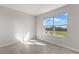 Bright bedroom featuring neutral colors, tile flooring, and a large window overlooking a green lawn at 9066 Rally Spring Loop, Wesley Chapel, FL 33545