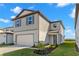 Charming home featuring a clean gray facade, manicured landscaping, and a two-car garage at 9066 Rally Spring Loop, Wesley Chapel, FL 33545