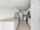 Modern kitchen featuring stainless steel appliances, granite countertops, and white cabinets at 9066 Rally Spring Loop, Wesley Chapel, FL 33545