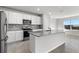 Modern kitchen with white cabinets, granite countertops, stainless steel appliances, and a central island at 9066 Rally Spring Loop, Wesley Chapel, FL 33545