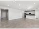 Bright open-concept living room with tiled floors and access to a modern kitchen at 9066 Rally Spring Loop, Wesley Chapel, FL 33545