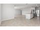 Bright open-concept living room with tiled floors and view of a modern kitchen at 9066 Rally Spring Loop, Wesley Chapel, FL 33545