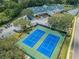 Aerial of the community center with tennis courts, plentiful parking, and lush landscaping at 9500 Green Needle Dr, New Port Richey, FL 34655