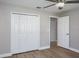 This bedroom has neutral walls, a ceiling fan, wide base trim and wood-look floors plus closet and ensuite access at 9500 Green Needle Dr, New Port Richey, FL 34655