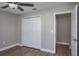 This bedroom has neutral walls, a ceiling fan, wide base trim and wood-look floors plus closet and ensuite access at 9500 Green Needle Dr, New Port Richey, FL 34655