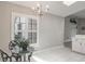 Sunlit breakfast nook features a modern chandelier and windows with plantation shutters at 9500 Green Needle Dr, New Port Richey, FL 34655