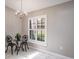 Bright breakfast nook featuring a modern chandelier and a sunlit window with plantation shutters at 9500 Green Needle Dr, New Port Richey, FL 34655