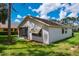Back of house with screened in porch and mature landscaping at 9500 Green Needle Dr, New Port Richey, FL 34655