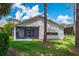 Rear exterior view showing the home's screened lanai and well-maintained lawn at 9500 Green Needle Dr, New Port Richey, FL 34655