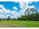 Scenic view of a lush green golf course with beautiful trees and clear blue skies at 9500 Green Needle Dr, New Port Richey, FL 34655