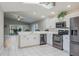 Open-concept kitchen featuring stainless appliances, white cabinetry and a seamless flow to living area at 9500 Green Needle Dr, New Port Richey, FL 34655