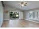Spacious living room features a vaulted ceiling, sliding glass doors, and wood-look vinyl flooring at 9500 Green Needle Dr, New Port Richey, FL 34655