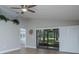 Sun-filled living room featuring a ceiling fan, vinyl floors, and sliding door access to the outdoors at 9500 Green Needle Dr, New Port Richey, FL 34655