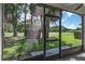 Enclosed patio with views of a lush green yard and mature trees, ideal for enjoying the outdoors in comfort at 9500 Green Needle Dr, New Port Richey, FL 34655