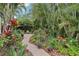 Lush backyard garden with brick pathway featuring tropical landscaping, trees, and flowers at 1014 7Th Street N, St Petersburg, FL 33701