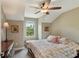 Bedroom showcases a ceiling fan, window, floral quilt and dresser with decorative lamps, creating a comfortable retreat at 1014 7Th Street N, St Petersburg, FL 33701