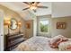 Cozy bedroom with a ceiling fan, dresser, lamps, and a floral pattern quilt on the bed at 1014 7Th Street N, St Petersburg, FL 33701