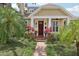Charming home exterior featuring a brick pathway, lush landscaping, and a welcoming red front door at 1014 7Th Street N, St Petersburg, FL 33701