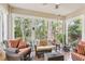 Bright sunroom featuring rattan furniture and large windows showcasing lush greenery at 1014 7Th Street N, St Petersburg, FL 33701