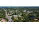 Aerial view of a residential area, featuring a pond, lush trees, and convenient access to the main thoroughfare at 107 Garland Cir, Palm Harbor, FL 34683